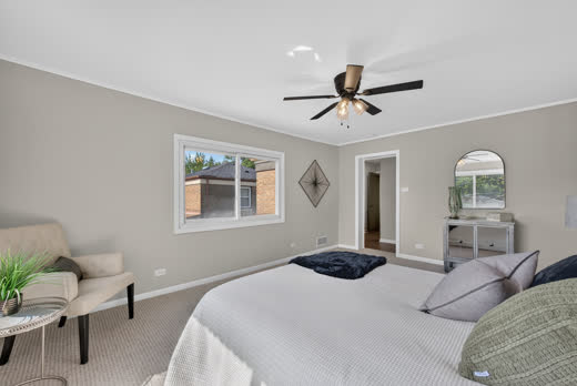 Large primary bedroom with sitting area and hallway access at 9205 S Utica Ave