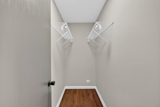 Walk-in closet with hardwood flooring and wire shelving at 9205 S Utica Ave