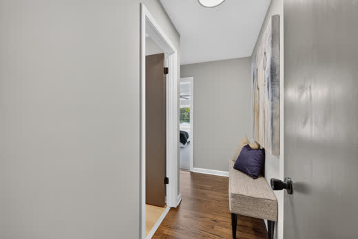 Hallway with hardwood floors and staged bench at 9205 S Utica Ave, Evergreen Park