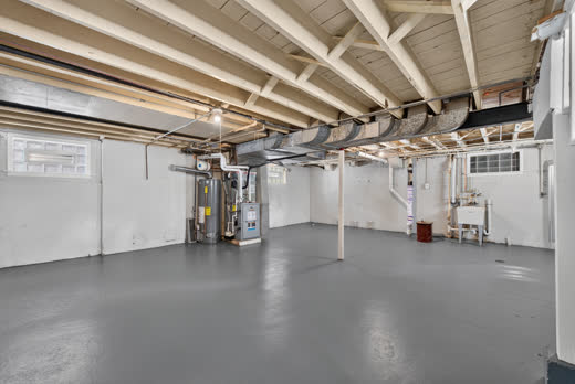 Clean painted basement with gray floors and glass block windows at 9205 S Utica Ave