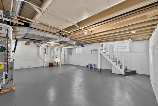 Spacious basement with painted floors and staircase at 9205 S Utica Ave