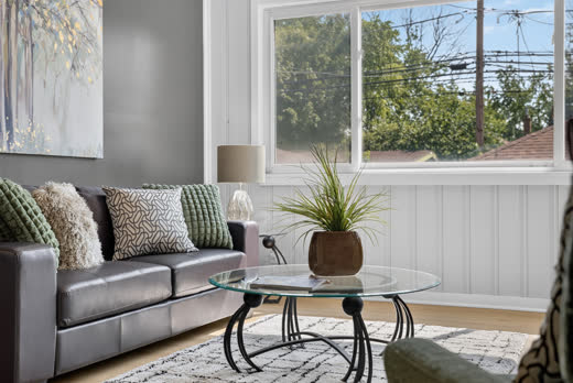 Bright sunroom sitting area with beadboard wainscoting at 9205 S Utica Ave