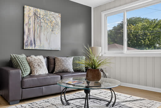 Sunroom lounge with accent wall and large windows at 9205 S Utica Ave
