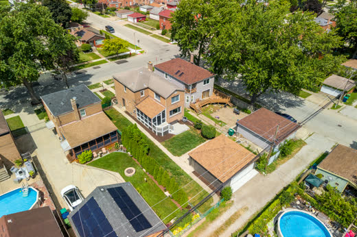 Aerial rear view of 9205 S Utica Ave showing addition, deck, backyard, and garage